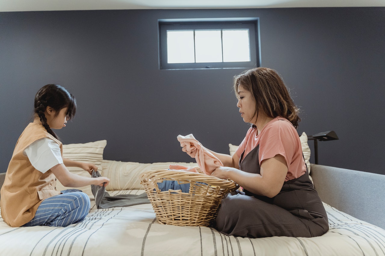 mother and daughter folding laundry