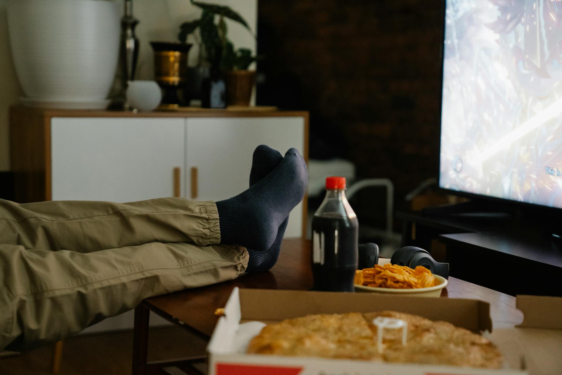 Person eating junkfood and watching television
