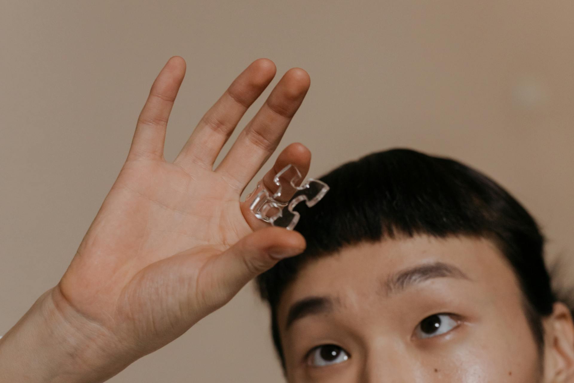 Person holding jigsaw puzzle piece